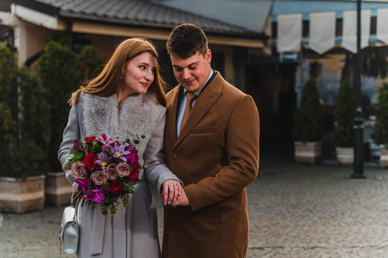 Un cuplu îmbrățișat intr-o zi de iarna, după casa căsătoriilor, ceremonia civilă din București. Se imbratiseaza, se privesc frumos și stau frumos îmbrățișați aranjați la ședința foto cu fotograful Dan Mihai Lupescu